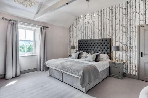 a bedroom with a bed and a wall with trees at The Farmhouse in Ravensworth