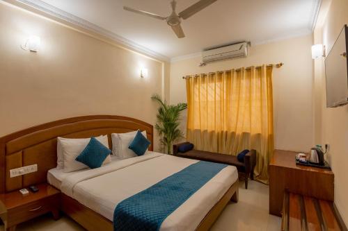 a hotel room with a bed and a window at Blue Bliss Hotel By PPH Living in Bangalore