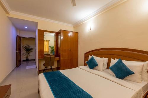 a bedroom with a bed with blue and white pillows at Blue Bliss Hotels By PPH Living Infantry Road in Bengaluru