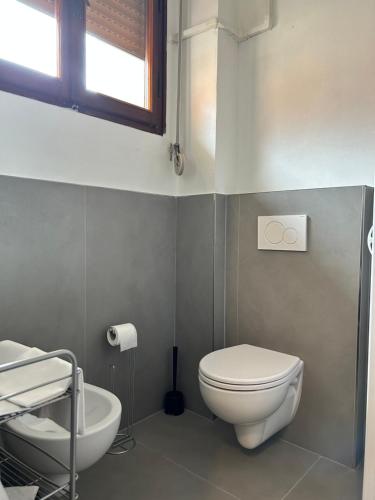 a bathroom with a white toilet and a sink at Hotel Cecile in Pisa