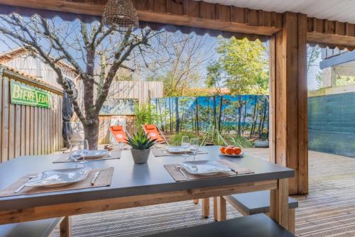 - une table avec des verres et des assiettes sur la terrasse dans l'établissement Comme Un Petit Chalet, à La Teste-de-Buch