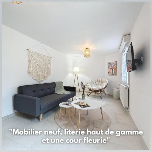a living room with a blue couch and a table at Le Jardin des Plantes Rouen Studios et F2 au calmes, Terrasse, stationnement gratuit in Rouen