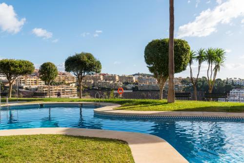 ein Schwimmbad in einem Park mit Bäumen und Gebäuden in der Unterkunft Casa del Sol: Sunrise to Sunset in Sitio de Calahonda