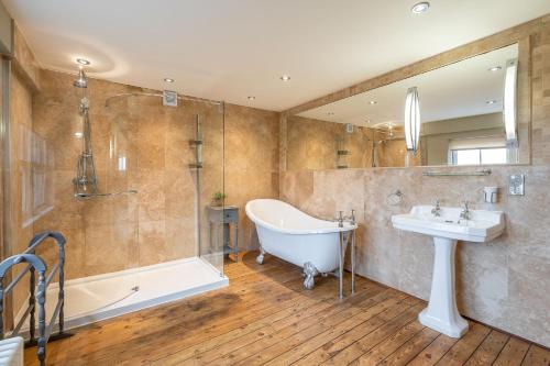 uma casa de banho com uma banheira e um lavatório e uma banheira em Harelands em Aldbrough