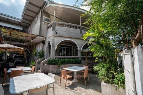 a patio with tables and chairs in front of a building at Legacy Mansion + coffee bar in Iloilo City