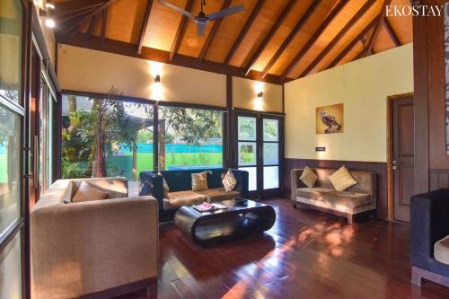 a living room with a couch and a table at EKO STAY- BALI VILLA in Alibaug
