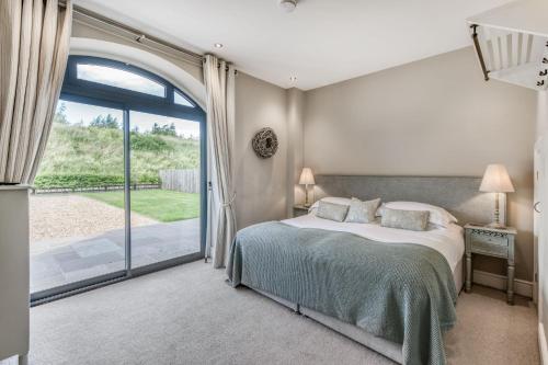 a bedroom with a bed and a sliding glass door at Shorthorn in Ravensworth