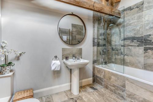 a bathroom with a sink and a shower and a mirror at Shorthorn in Ravensworth