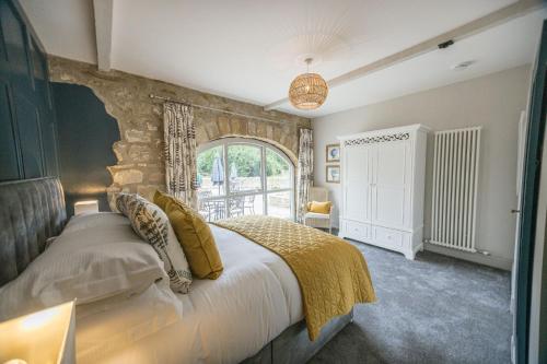 a bedroom with a large bed with a stone wall at Kingfisher in Forcett
