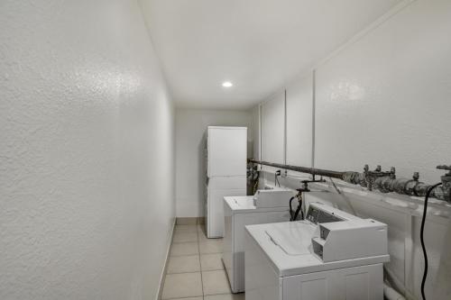 a white bathroom with three sinks and a refrigerator at Motel 6-Dallas, TX - South in Dallas