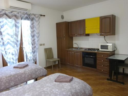 mały pokój z 2 łóżkami i kuchnią w obiekcie Cjase Paola w mieście Cassacco