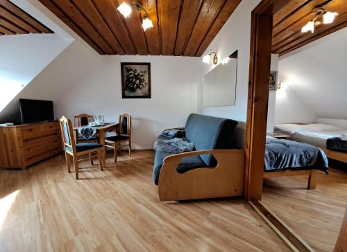 a bedroom with a bed and a dining room with a table at Willa Sawina in Sromowce Niżne