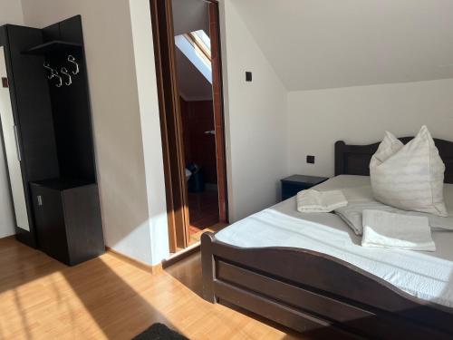 a bedroom with a bed with white sheets and pillows at Casa Tofalvi in Sovata