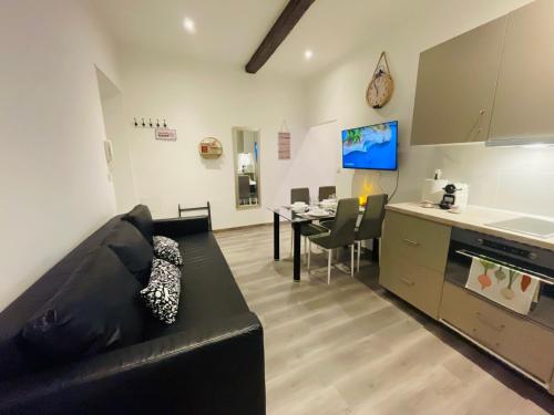 un salon avec un canapé noir et une cuisine dans l'établissement APRT Cannes Beach Festival ARNESE, à Cannes