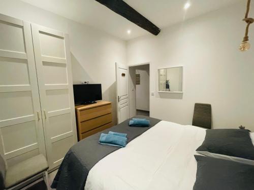 une chambre avec un lit blanc et une télévision dans l'établissement APRT Cannes Beach Festival ARNESE, à Cannes