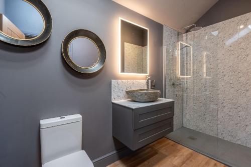 a bathroom with a sink and a mirror at Bearskin Cottage in Leyburn