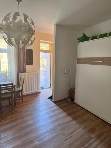 een woonkamer met een tafel en een grote witte koelkast bij Apartmán U Splavu in Teplice nad Metují