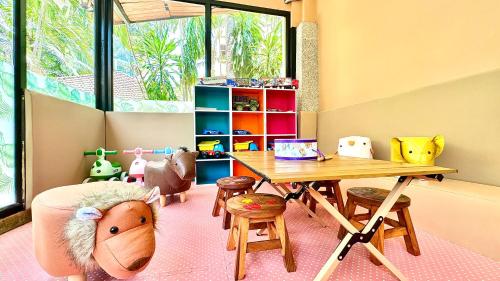 een speelkamer voor kinderen met een tafel en stoelen bij Princess Kamala Beachfront Hotel - SHA Extra Plus in Kamala Beach