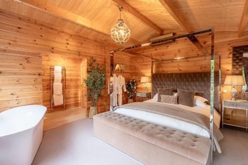 a log cabin bedroom with a bed and a tub at Sun Hill Farmhouse in Leyburn