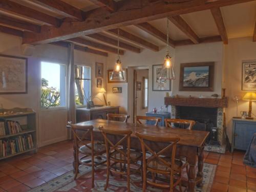 une salle à manger avec une table et des chaises en bois dans l'établissement Maison au bord de mer avec jardin paysager, proche port et commerces à Sauzon - FR-1-418-49, à Sauzon