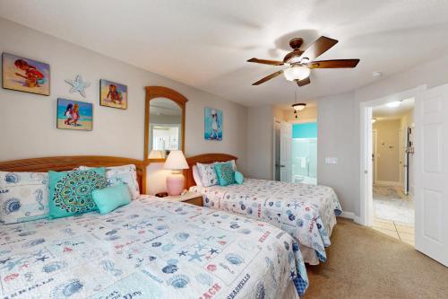 a bedroom with two beds and a ceiling fan at Tee Time Beach Time in Calabash