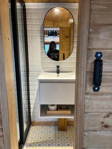 a woman taking a picture in a bathroom mirror at In Situ Mar in Pichilemu