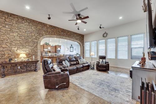 a living room with leather furniture and a stone wall at Poolside Relaxation Queen Creek Oasis with Fire Pit in Queen Creek
