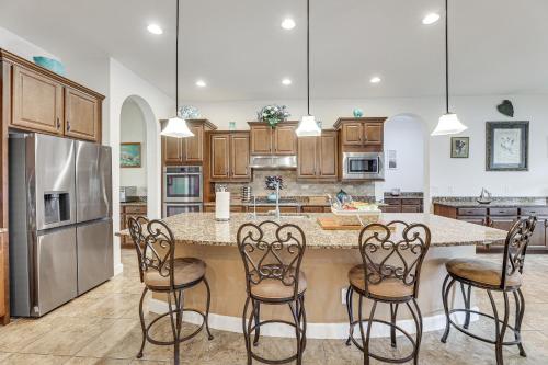 a kitchen with a large island with bar stools at Poolside Relaxation Queen Creek Oasis with Fire Pit in Queen Creek