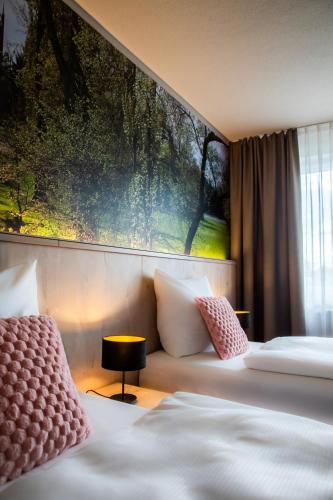 a hotel room with two beds and a painting on the wall at Hotel Restaurant Elbebrücke in Oranienbaum-Wörlitz
