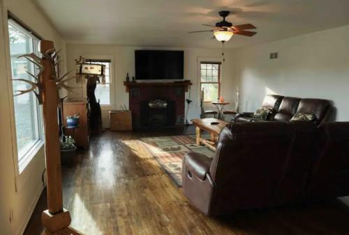 a living room with a couch and a flat screen tv at Sportsman Lodge Melrose MT in Melrose