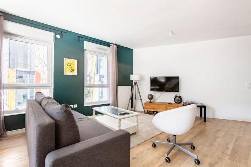 a living room with a couch and a chair at Grand appartement , Paris la Défense Arena, 50 mètres de la gare, 15 min Champs elysées in Nanterre