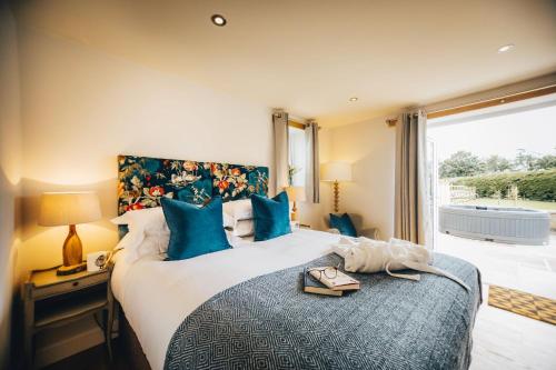 a bedroom with a large bed with blue pillows at Millfield Barn in Richmond