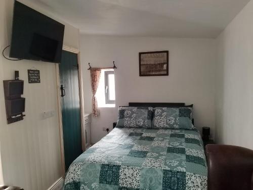 1 dormitorio con 1 cama con edredón verde en Blakes Barn in Carrigaholt, en Kilrush