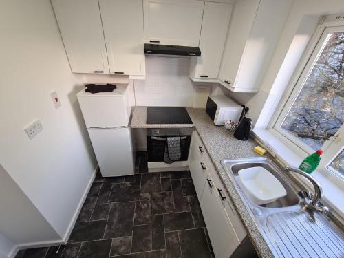 a small kitchen with a sink and a stove at 2 Bedroom Modern Apartment in Earl Shilton