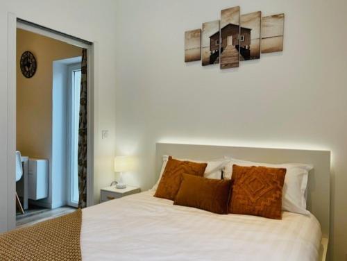 une chambre avec un grand lit blanc avec des oreillers orange dans l'établissement Charmant et lumineux appartement, à Montpellier