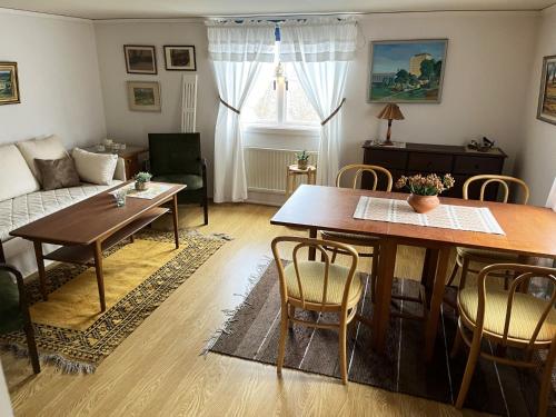 salon ze stołem i kanapą w obiekcie Red cottage with a nice view of the landscape, at Aboda Klint w mieście Alsterbro