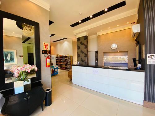 a lobby of a store with a counter and flowers at SHELTON PALACE HOTEL in Paranavaí