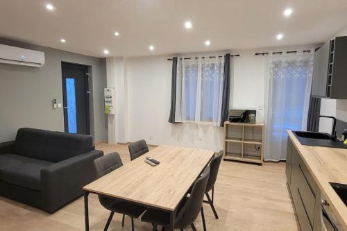 une cuisine et un salon avec une table et des chaises dans l'établissement Superbe appartement T2 climatisé, idéalement situé, à Ugine