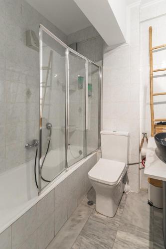 a white bathroom with a shower and a toilet at AcroLofts M62 in Athens