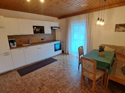 uma cozinha e sala de estar com uma mesa e um sofá em Apartment Waldfrieden by Interhome em Oberwang