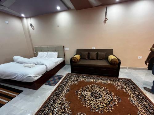 Cette chambre comprend deux lits, un canapé et un tapis. dans l'établissement Preeti's Nest, à Varanasi