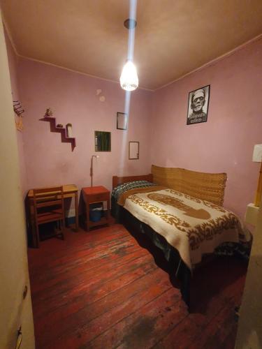 a bedroom with a bed and a wooden floor at Hospedaje Frankenstein in Cusco