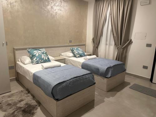 2 camas individuales en una habitación con ventana en Villa Lucia en Pompeya