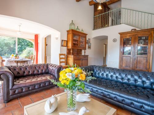 - un salon avec un canapé en cuir et des fleurs sur une table dans l'établissement Holiday Home Bartavelle by Interhome, à Guerre Vieille