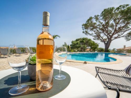 - une bouteille de vin assise sur une table avec des verres à vin dans l'établissement Villa Cacharel - MAX230 by Interhome, à Sainte-Maxime