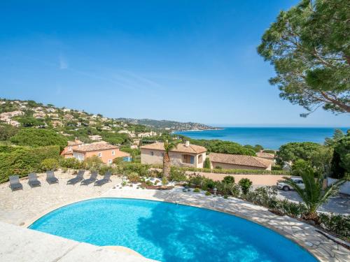 une piscine avec des chaises et l'océan en arrière-plan dans l'établissement Villa Cacharel by Interhome, à Sainte-Maxime