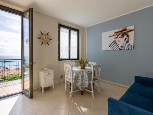 a living room with a blue couch and a table with chairs at Apartment Rosy by Interhome in Costarainera