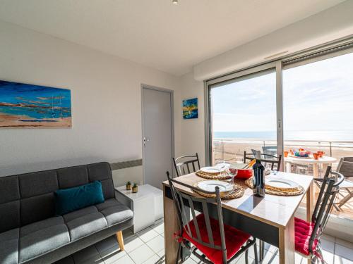 a dining room with a table and a couch at Apartment Les Terrasses du Levant by Interhome in Narbonne-Plage