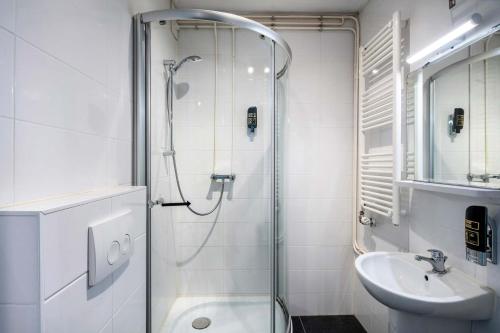 W łazience znajduje się prysznic i umywalka. w obiekcie Hotel Atlantis Amsterdam w Amsterdamie