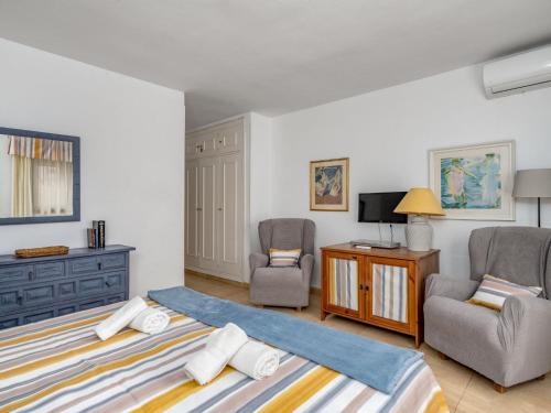 a bedroom with a bed and two chairs and a tv at Apartment Dona Lola by Interhome in Sitio de Calahonda